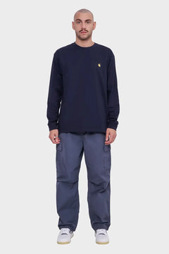 Mężczyzna w granatowej bluzie z długim rękawem i szarych spodniach cargo, styl streetwear
