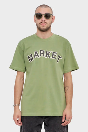 Mężczyzna w zielonej koszulce MARKET, okulary przeciwsłoneczne, casualowy styl