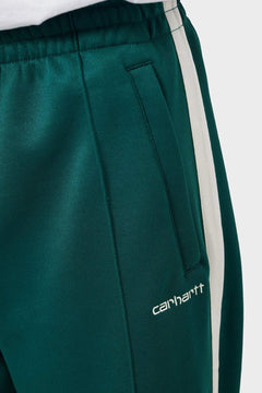 zielone spodnie dresowe z białym paskiem i logo Carhartt, detal kieszeni