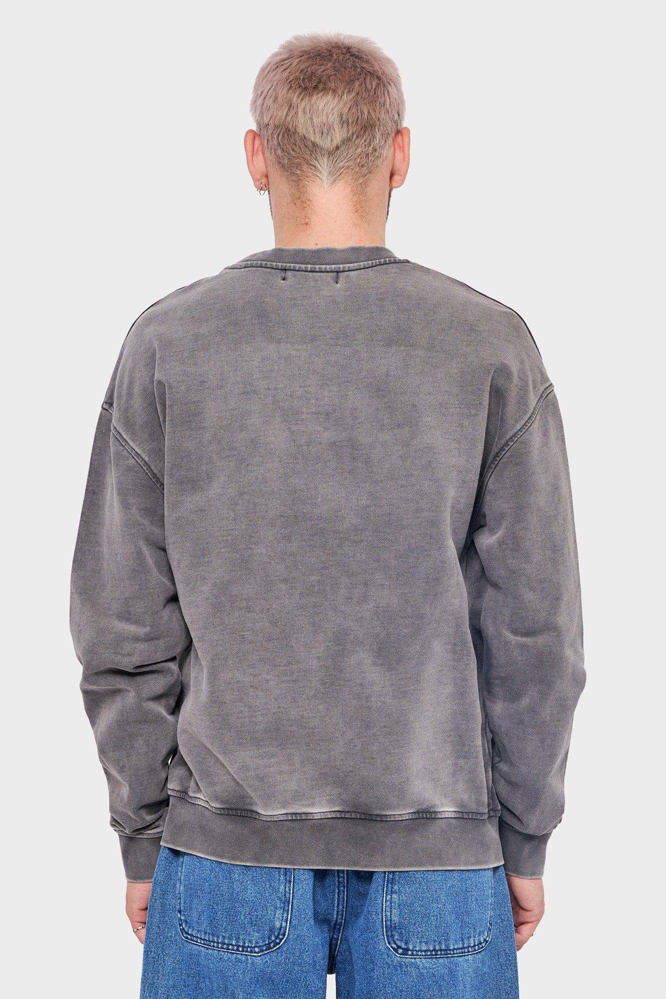 Mężczyzna w spranej szarej bluzie oversize, widok z tyłu, dżinsy, styl streetwear
