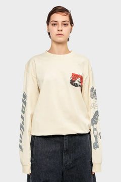 Modelka w kremowej bluzie z nadrukami motoryzacyjnymi na rękawach i kieszeni, modne ubrania streetwear.