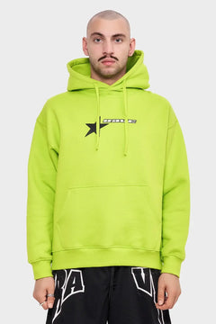 Mężczyzna w neonowej zielonej bluzie z kapturem i czarnym nadrukiem, styl streetwear
