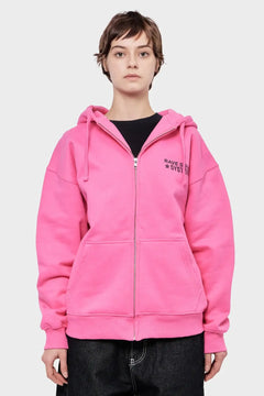 Modelka w różowej bluzie z kapturem, napisem RAVE SYSTEM, moda streetwear.